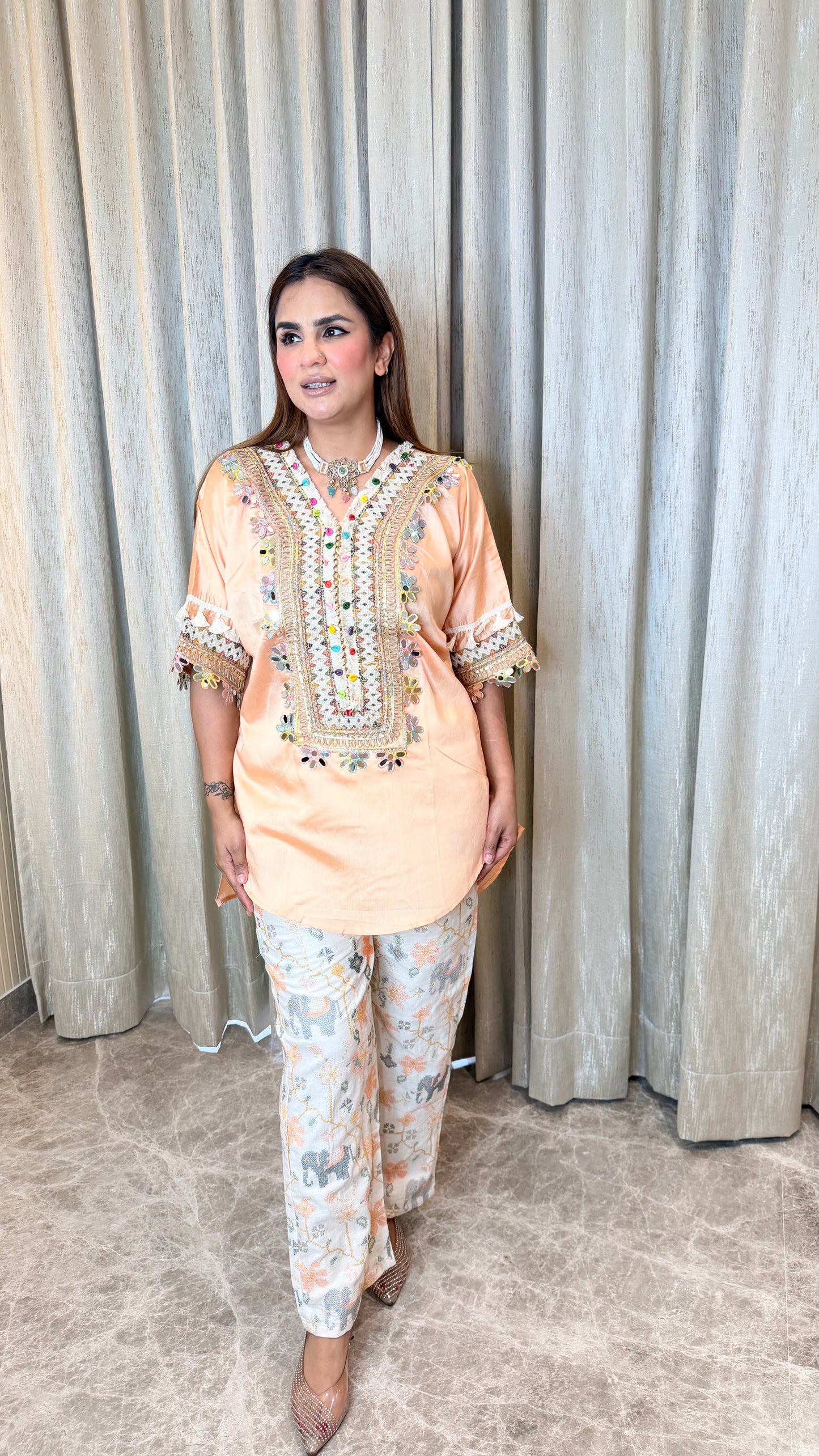 Elegant peach-colored embroidered tunic paired with patterned printed trousers pc3595